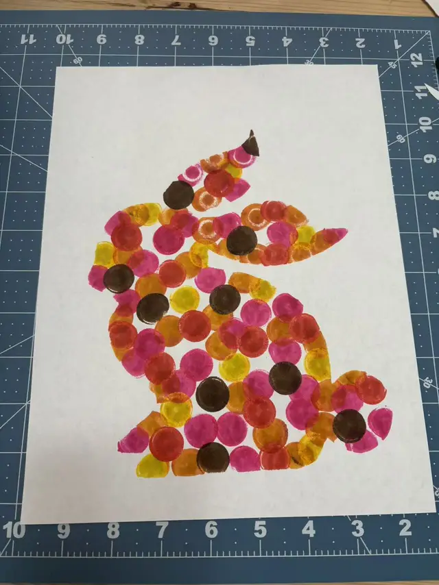 A rabbit made of overlapping painted dots in pink, orange, and yellow