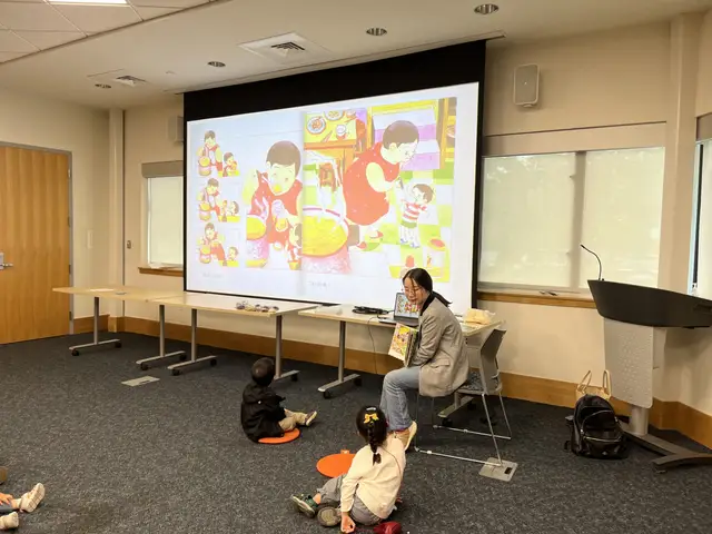 A story leader reads beside a projected Mandarin picture book at a library story time session